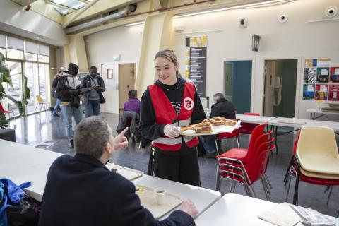 Une bénévoles et une personnes accueillant à un petit déjeuner au chaud de l'Armée du Salut