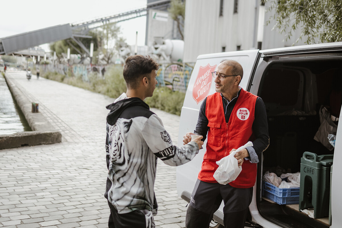 Kamel Haddad, saalarié à l'Armée du Salut, donne un café à un homme sans domicile, lors d'une maraude de l'association dans les rues Paris, lundi 01 juillet 2024.