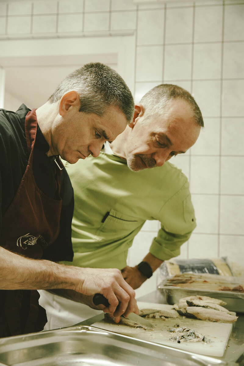 PASCAL LIENDLY (chef de cuisine) et CHRISTOPHE NUNES (cuisinier en insertion à la brasserie) préparent le repas du midi